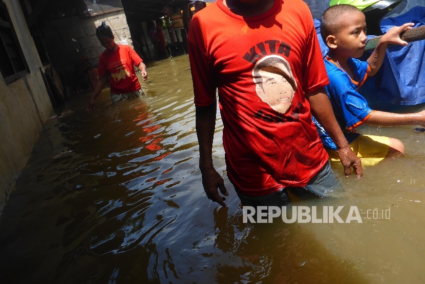 Warga sekitar Kali Strada kawasan Pejaten melintasi genangan banjir yang merendam rumahnya setelah hujan deras yang melanda Jakarta Selatan, Kamis (21/4). (Republika/ Yogi Ardhi)