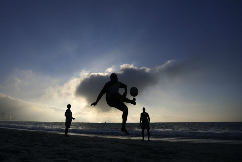 Warga setempat bermain bola di hamparan pasir Pantai Copacabana, Rio de Janeiro, Brasil. 