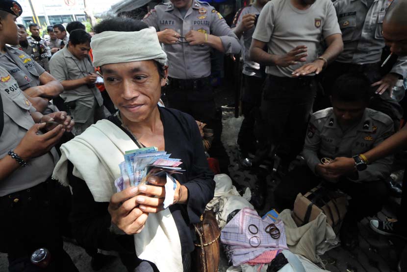 Warga suku asli Baduy menjajakan dagangan khas daerahnya kepada para polisi yang sedang bertugas di kawasan Bundaran Hotel Indonesia (HI), Jakarta, Selasa (6/5).