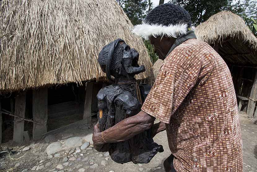  Warga Suku Dani membawa Mumi (jenazah yang diawetkan) Wim Motok Mabel kembali ke dalam Honai (rumah adat Papua) di Desa Jiwika, Distrik Kurulu, Kabupaten Jayawijaya.