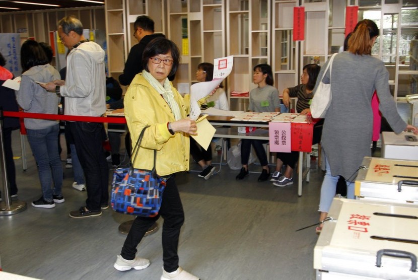 Warga Taiwan berbaris untuk memberikan pilihan mereka di TPS, Sabtu (24/11), di Taipei, Taiwan.