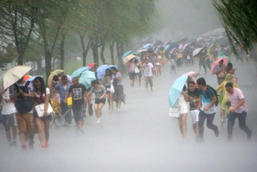 Warga Taiwan memakai payung untuk berlindung dari Topan Soudelor, Jumat (7/8).