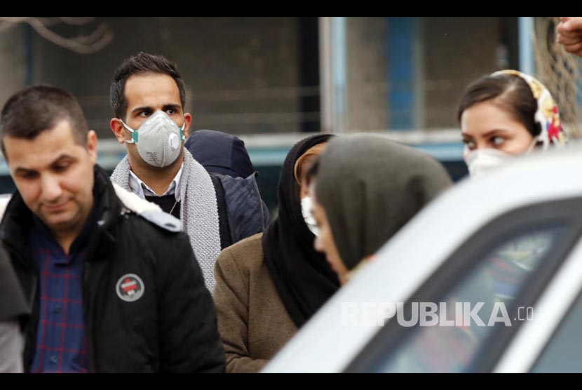 Warga Teheran Iran melintasi jalanan kota menggunakan masker. Iran mungkin akan terapkan pembatasan karena penambahan infeksi Covid-19. Ilustrasi.