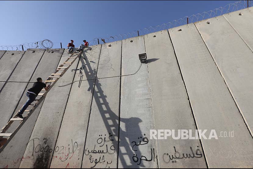 Pangeran Saudi Sebut Tembok Israel Sebagai Tembok Apartheid. Warga Tepi Barat Palestina menaiki tangga untuk menlintasi tembok pemisah yang dipasang Israel untuk shalat jumat di Kompleks Al Aqsa, Jumat (8/6). Mereka dilarang memasuki Yerusalem berdasar batas umur minimal yang boleh memasuki Al Aqsa. 