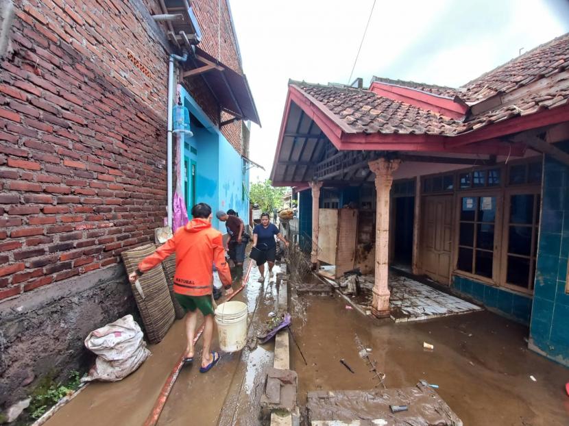 Warga terdampak banjir bandang di Kampung Sudika Indah, Desa Haurpanggung, Kecamatan Tarogong Kidul, Kabupaten Garut, membersihkan rumah mereka pada Ahad (17/7/2022). 