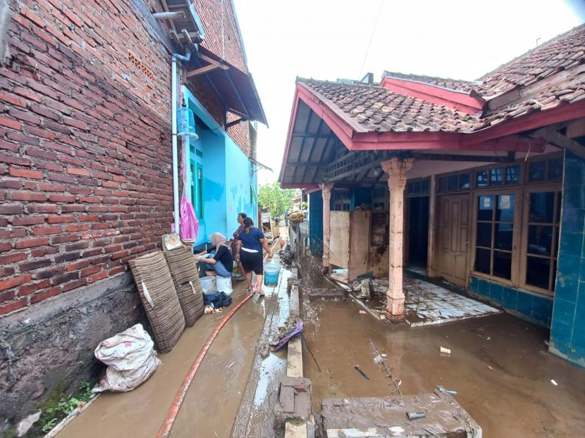 Warga terdampak banjir bandang di Kampung Sudika Indah, Desa Haurpanggung, Kecamatan Tarogong Kidul, Kabupaten Garut, membersihkan rumah mereka pada Ahad (17/7/2022). 