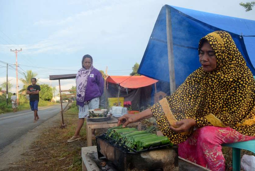 Warga terdampak gempa dan tsunami Palu-Donggala menjual penganan di kawasan pengungsian hunian sementara yang dibangun warga di Biromaru, Kabupaten Sigi, Sulawesi Tengah, Sabtu (13/10).