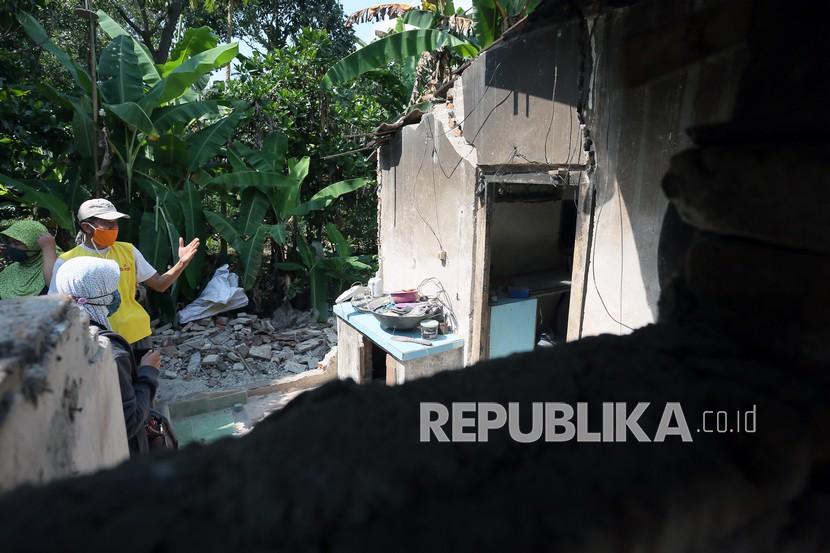 Warga terdampak gempa menunjukkan bangunan rumahnya yang rusak di Desa Jabung Kecamatan Talun, Blitar, Jawa Timur, Sabtu (22/5/2021). BPBD setempat mendata sebanyak 112 bangunan rumah warga dan fasilitas umum rusak ringan dan berat serta seorang warga mengalami luka ringan akibat gempa magnitudo 5,9 SR yang berpusat di lepas pantai selatan Blitar pada Jumat (21/5/2021) malam, .
