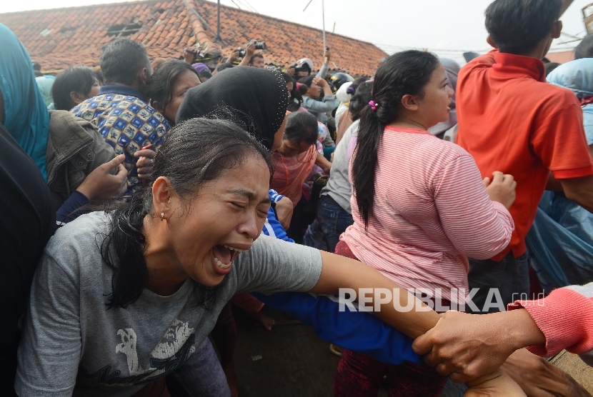  Warga teriak histeris saat menolak penertiban yang dilakukan di Pasar Ikan Penjaringan, Jakarta Utara, Senin (11/4). (Republika/Raisan Al Farisi)