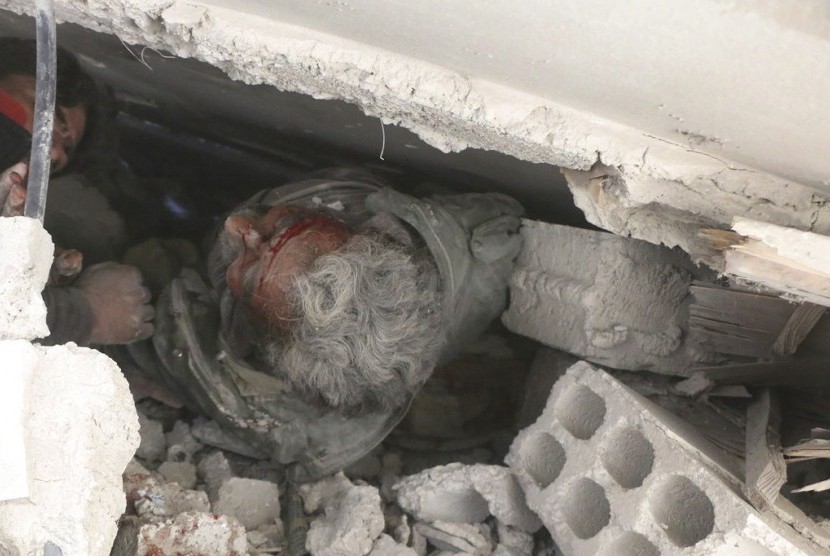 Warga terluka dan terjebak dalam reruntuhan bangunan akibat serangan udara pasukan pemerintah Suriah di Ghouta, pinggiran Damaskus, Suriah, Selasa (20/2).