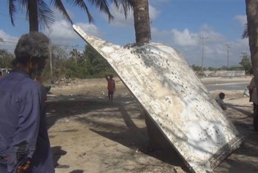 Warga Thailand melihat potongan logam yang terdampar di sebuah pantai di provinsi Nakhon Si Thammarat, Ahad, 24 Januari 2016. Penemuan itu memicu spekulasi apakah potongan logam itu berasal dari pesawat MH370.