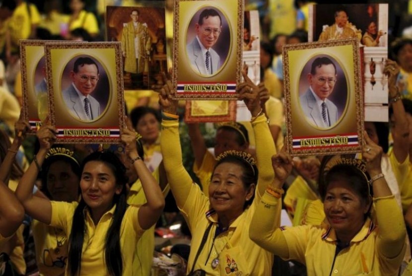 Warga Thailand membawa potret Raja Bhumibol Adulyadej.