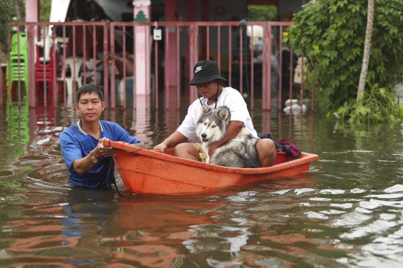Warga Thailand mengarungi banjir, Kamis, 29 September 2022, di provinsi Ubon Ratchathani, timur laut Thailand. Hujan lebat dan angin kencang akibat badai tropis Noru menyapu sebagian wilayah timur laut Thailand pada Kamis pagi, merobohkan pepohonan dan memicu banjir bandang di beberapa daerah.