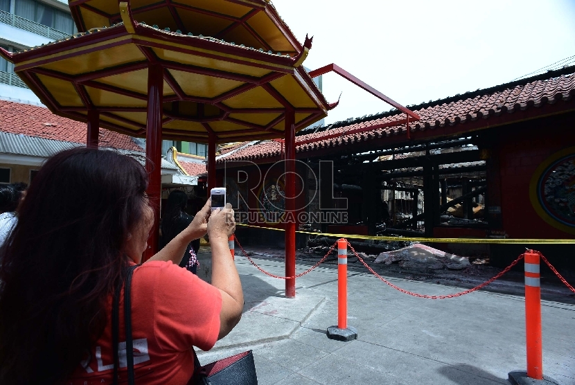 Warga Tionghoa memotret Vihara Dharma Bhakti yang sudah terbakar di Petak Sembilan, Jakarta Barat, Kamis (5/3).