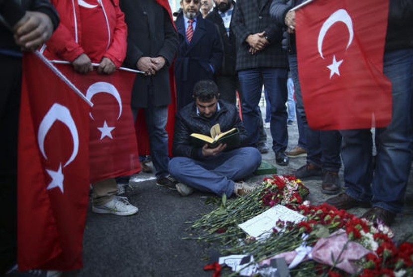 Warga Turki berkumpul membaca doa dan meletakkan bunga sebagai penghormatan terhadap korban dua bom di luar stadion Besiktas di Istanbul.