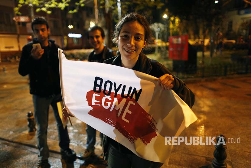 Warga Turki yang menolak hasil referendum membawa spanduk bertuliskan 'jangan patuhi' di Istanbul (16/4)