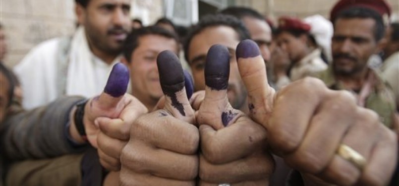 Warga Yaman menunjukkan jari-jari mereka yang telah dicelupi tinta sebagai tanda telah mencoblos di TPS di Sana'an, (Selasa, 21/2).