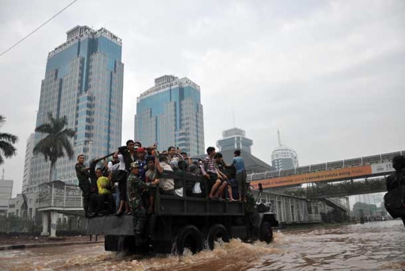 Warga yang bekerja di kawasan Sudirman terpaksa harus di evakuasi menggunakan truk untuk melintasi air banjir yang menggenangi kawasan Jalan Sudirman,Jakarta Pusat, Kamis (17/1).