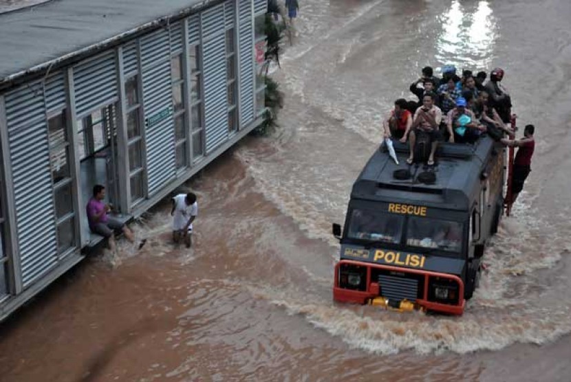 Warga yang bekerja di kawasan Sudirman terpaksa harus di evakuasi menggunakan mobil Rantis untuk melintasi air banjir yang menggenangi kawasan Jalan Sudirman,Jakarta Pusat, Kamis (17/1).
