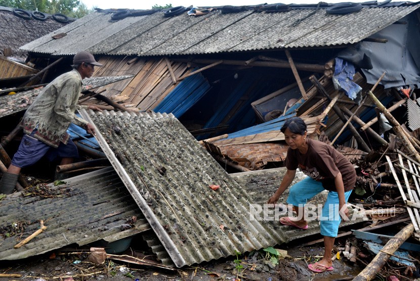 Warga yang rumahnya roboh dihantam tsunami mengambil atap untuk dipasang lagi di Kampung Sinar Laut, Kecamatan Panimbang, Pandeglang, Banten, Ahad (23/12/2018). 