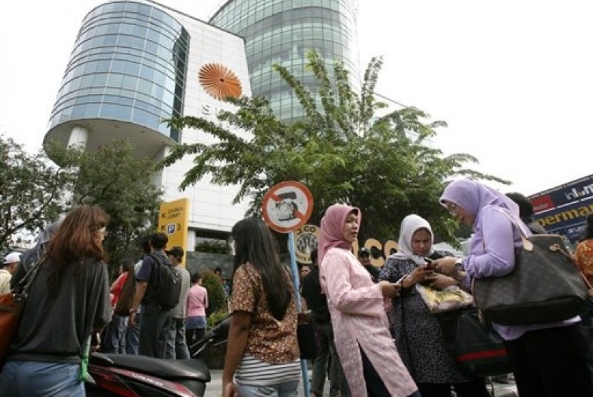 Warga yang tengah berbelanja tampak berkerumun usai dievakuasi dari sebuah mal di Medan, Sumut, Rabu (11/4).