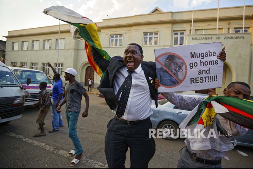 Warga Zimbabwe berpesta di depan Gedung Parlemen setelah mendengar berita pengundurandiri presiden Mugabe di Harare, Zimbabwe, Selasa (21/11).