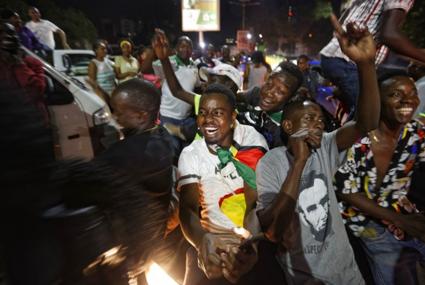 Warga Zimbabwe merayakan mundurnya Robert Mugabe sebagai presiden di Harare, Zimbabwe, Selasa malam (21/11).