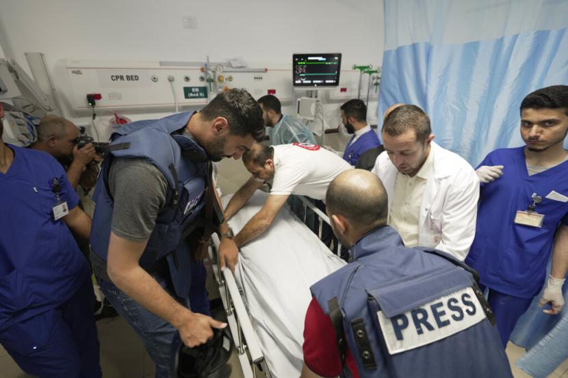Wartawan dan petugas medis mengelilingi jenazah Shireen Abu Akleh, seorang jurnalis untuk jaringan Al Jazeera, ke kamar mayat di dalam Rumah Sakit di kota Jenin, Tepi Barat, Rabu, 11 Mei 2022. Wartawan Palestina terkenal untuk penyiar berbahasa Arab Saluran itu ditembak dan dibunuh saat meliput serangan Israel di kota Jenin di Tepi Barat yang diduduki Rabu pagi, kata kementerian kesehatan Palestina.