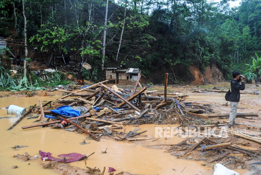 Wartawan meliput di area pemukiman yang porak poranda diterjang banjir bandang di Kampung Panggeleseran, Desa Citorek Kidul, Lebak, Banten, Ahad (8/12/2019).