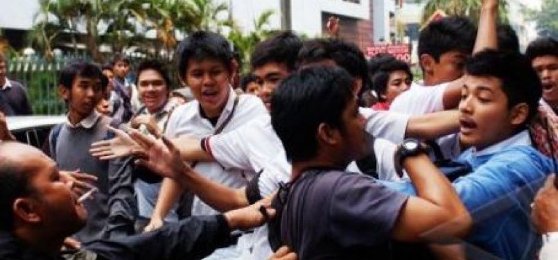 Wartawan terdesak (kiri), oleh puluhan pelajar SMA 6, saat terjadi rusuh di depan Gedung SMA 6, Jakarta, Senin (19/9). 