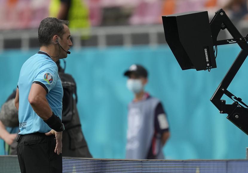 Wasit melihat tayangan ulang video asisten wasit (VAR).