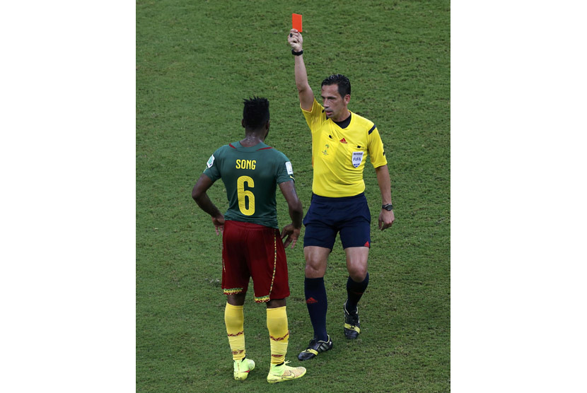 Wasit asal Portugal, Pedro Proenca (kanan), mengganjar kartu merah pemain Kamerun, Alexandre Song, saat menghadapi Kroasia di laga Grup A Piala Dunia 2014 Brasil di Arena Amazonia, Manaus, Rabu (18/6). 