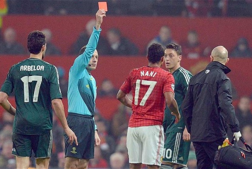 Wasit Cuneyt Cakir saat mengusir Nani di leg kedua 16 besar Liga Champions, Rabu (6/3) lalu.