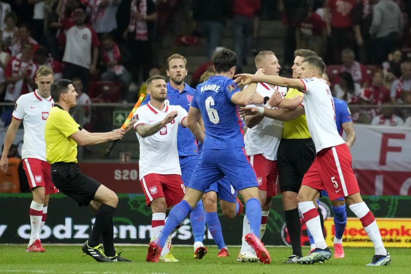 Wasit dan hakim garis turun tangan saat terjadi keributan di antara para pemain di akhir babak pertama dalam pertandingan sepak bola kualifikasi Grup I Piala Dunia 2022 antara Polandia dan Inggris, di Stadion Narodowy di Warsawa, Rabu, 8 September 2021.