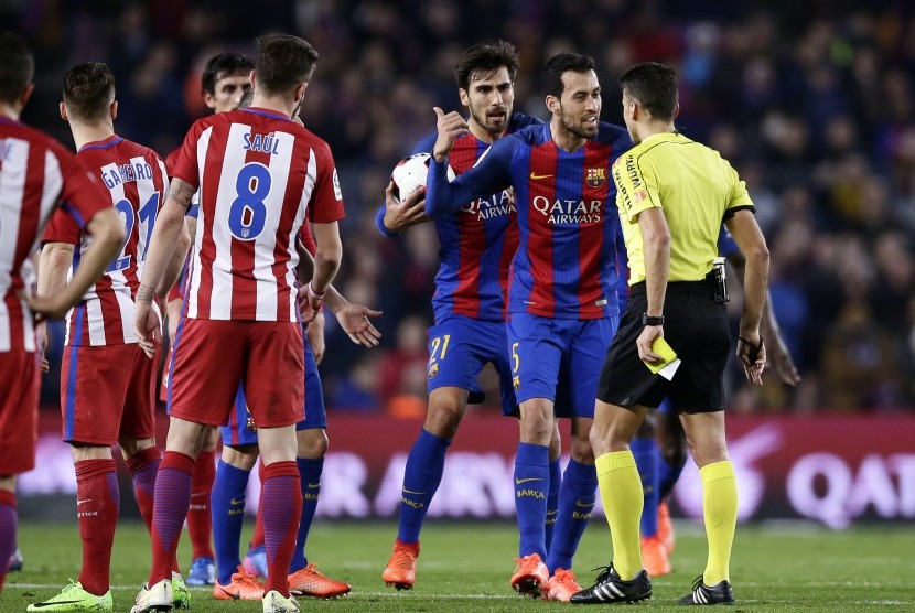 Wasit Gil Manzano (kanan) beradu argumentasi dengan gelandang Barcelona, Sergio Busquets pada laga Copa del Rey di Camp Nou, Rabu (8/2) dini hari WIB. Laga berakhir imbang 1-1.