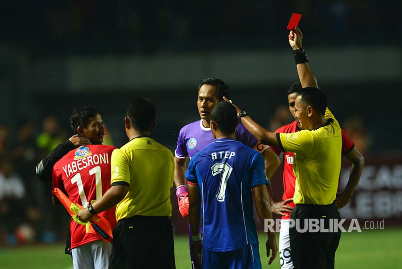 [ilustrasi] Wasit Haryadi memberikan kartu kuning kedua kepada winger Bali United Yaberoni yang tengah ditenangkan pelatih Persib Djadjang Nurjaman di Stadion GBLA, Bandung Sabtu (8/4). 