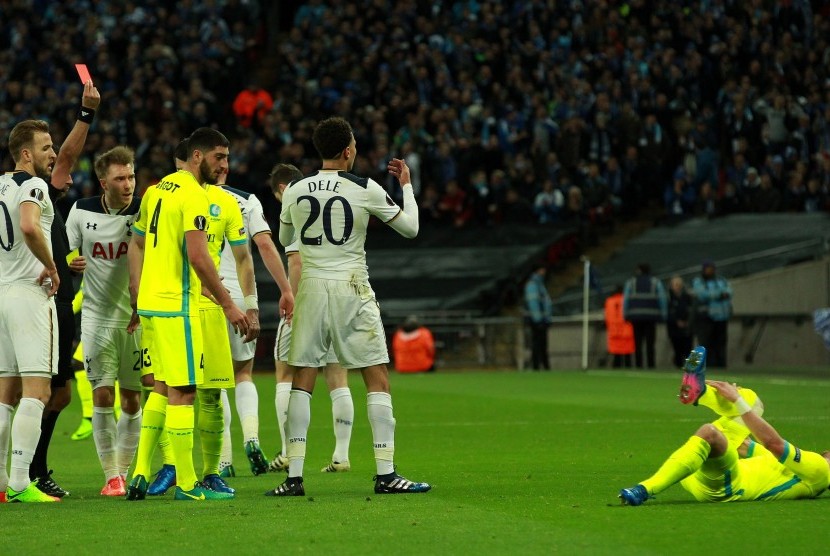 Wasit mengartu merah gelandang Tottenham Hotspur, Dele Alli (nomor 20) setelah tekel keras terhadap pemain KAA Gent, Brecht Dajaegere (kanan) pada laga Liga Europa di Wembley, Jumat (24/2) dini hari WIB.