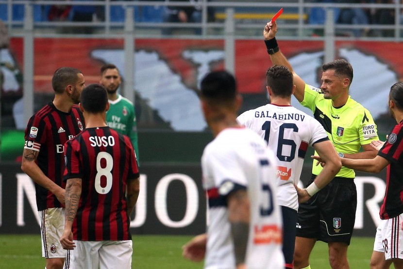 Wasit Piero Giacomelli (kedua dari kanan) memberikan kartu merah kepada kapten AC Milan Leonardo Bonucci (kiri) pada laga Rossoneri kontra Genoa di Stadion San Siro, Ahad (22/10). 