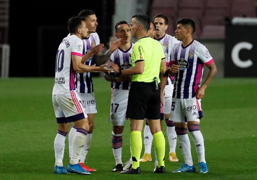 Wasit Santiago Jaime Latre (tengah) berbicara dengan para pemain Real Valladolid yang melancarkan protes saat melawan Barcelona.
