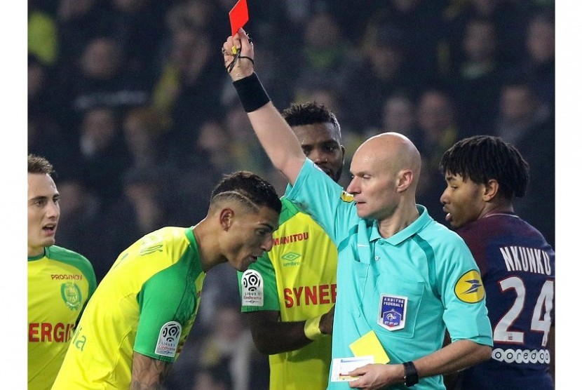 Wasit Tony Chapron memberikan kartu merah kepada pemain Nantes Diego Carlos dalam pertandingan melawan Paris Saint Germain (PSG) di Stadion Beaujoire, Nantes, Senin (15/1) dini hari WIB. 