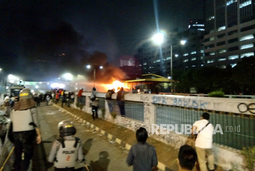 Water cannon kepolisian berusaha memadamkan api yang berada di Gerbang Tol Pejompongan, Jakarta, Selasa (24/9).