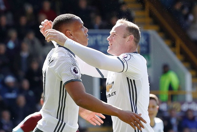 Wayne Rooney (kanan) dan Anthony Martial, pencetak dua gol Manchester United ke gawang Burnley, Ahad (23/4).