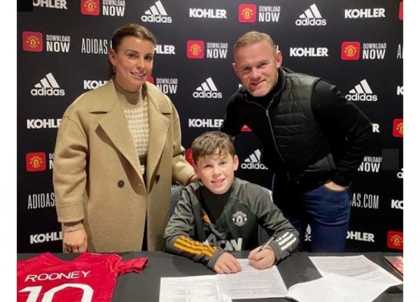 Wayne Rooney (kanan) mendampingi anaknya Kai (tengah) menandatangani kontrak bergabung dengan akademi Manchester United.