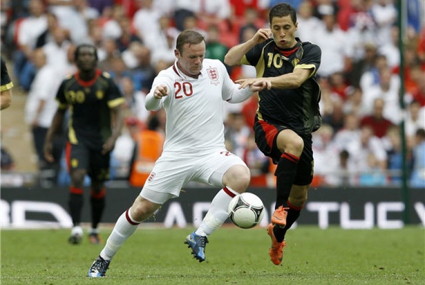 Wayne Rooney (kiri), striker timnas Inggris, berebut bola dengan pemain timnas Belgia, Eden Hazard, dalam laga uji coba di Stadion Wembley, London, Sabtu (2/6). 