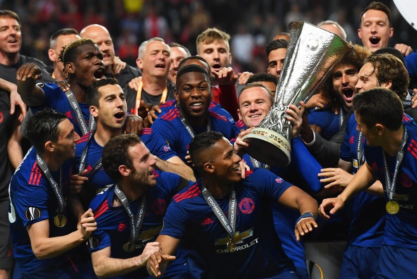 Wayne Rooney mengangkat trofi Liga Europa bersama skuat Manchester United setelah menang 2-0 atas Ajax Amsterdam pada laga final Liga Europa di Friends Arena, Kamis (25/5) dini hari WIB.