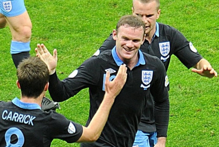 Wayne Rooney merayakan gol Inggris dengan rekan-rekannya pada partai melawan Polandia di Warsawa, Rabu (17/10) malam.