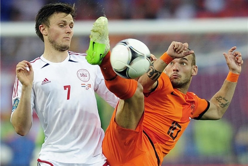 Wesley Sneijder (kanan), playmaker timnas Belanda, berjibaku berebut bola dengan pemain Denmark, William Kvist, di laga Grup B Piala Eropa 2012 di Kharkiv, Ukraina, Sabtu (9/6). 