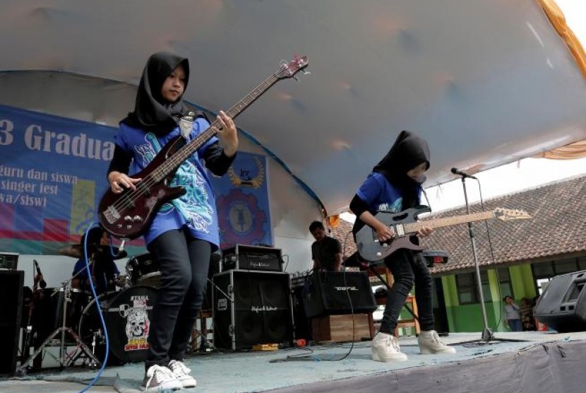 Widi Rahmawati (kiri) dan Firdda Kurnia, anggota band metal Voice of Baceprot (VOB) saat tampil di acara perpisahan sekolah di Garut, 15 Mei 2017. 