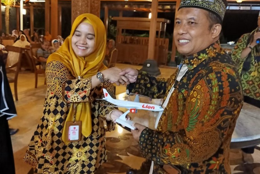 Widi Wiyanti, Area Manager Lion Yogyakarta dan Solo (kiri)  menyerahkan miniatur pesawat Lion Air kepada Direktur Sumber Daya Manusia (SDM)  Madinah Iman Wisata (MIW), Sahlan Toro.