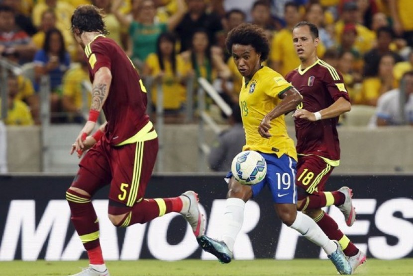 Willian (tengah) dijaga dua pemain Venezuela